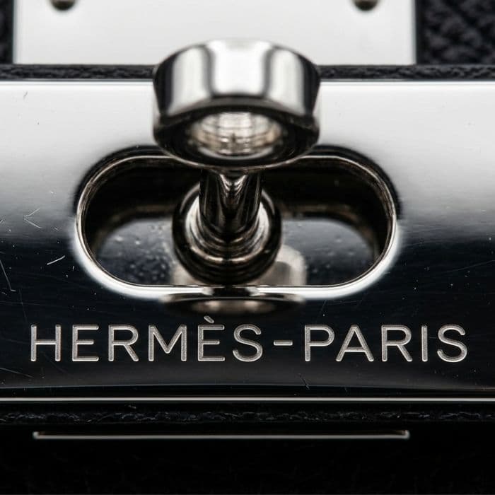 Detailed view of Hermès Birkin palladium hardware and protective stickers